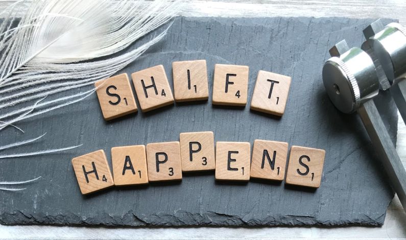 Career Mentor - scrabble chips forming shift happens word near white feather