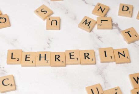 Mentorship - Scrabble tiles spelling lehrerin on a white marble surface