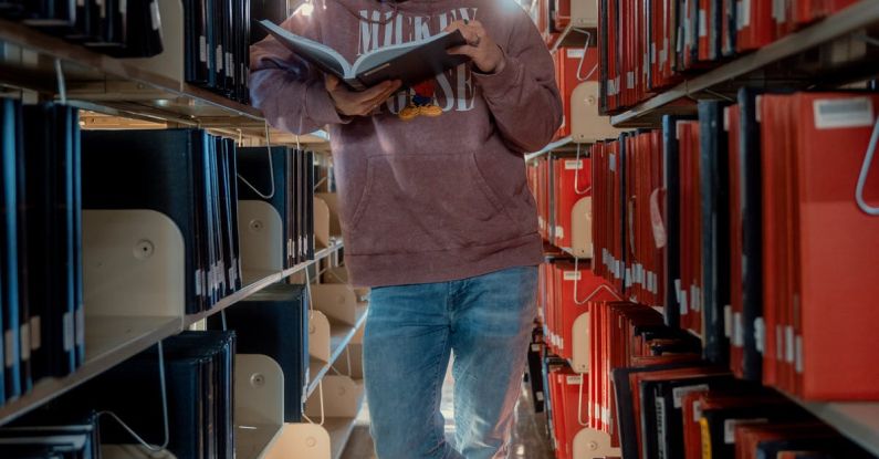 Student Loans - Man Reading Book In Library