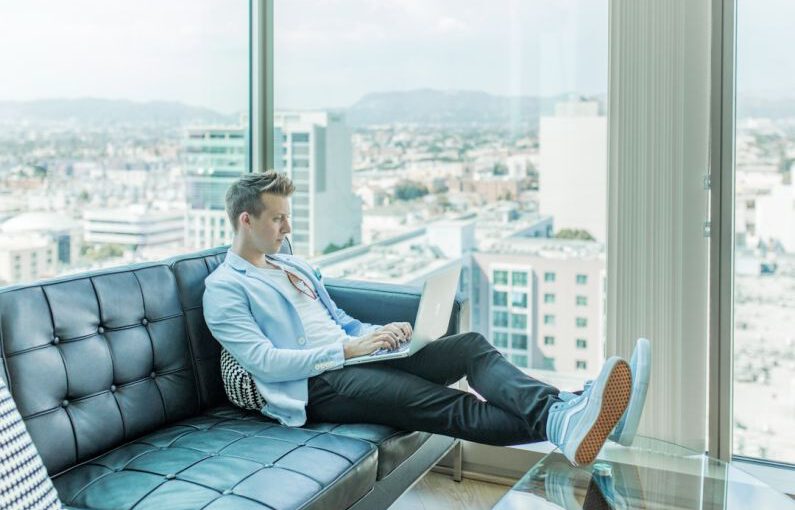 Freelance Profile - man sitting on sofa while using laptop